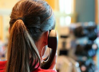 Niedersachsen erweitert Erreichbarkeit der Corona-Hotline Frau am Telefon