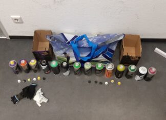 Graffiti-Sprayer auf frischer Tat ertappt – noch frische Farbe an den Händen.