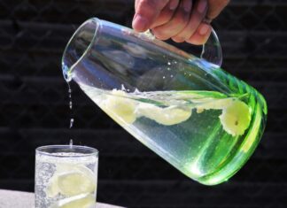 Gesundheitsrisiko Sommerhitze – so schützen Sie sich und andere gegen Hitzschlag, Sonnenstich & Co. Karaffe mit Wasser und Glas