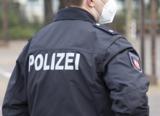 Ab 1. Januar 2022 gilt bei allen Versammlungen in der Landeshauptstadt Hannover eine Maskenpflicht Polizist mit Maske