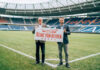 96-Geschäftsführer Martin Kind (l.) und Dr. Helge Mensching, Geschäftsführer von Heinz von Heiden, präsentieren das Logo der Heinz von Heiden-Arena im Innenraum des Stadions.