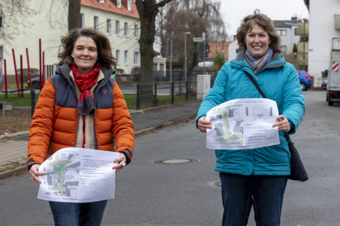 Christine Söhlke (links) und Anette Mecke zeigen die Pläne für den Bereich der Bachstraße. Hinter ihnen ist die geplante Sperrung, im Bereich des Spielplatzes, angedacht.