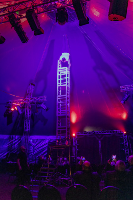 Luis Frank, vom Zirkus Showkolade begeisterte zum Abschluss mit einem akrobatischen Handstand, auf fünf gestapelten Stühlen, die auf vier Sektflaschen standen, hoch oben unter der Kuppel des Zirkuszeltes.