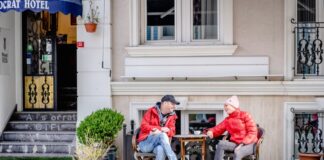 Mann und Frau sitzen draußen am Tisch und klönen