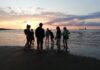 Ferienhits 2022 - Jugendgruppe am Strand im Sonnenuntergang