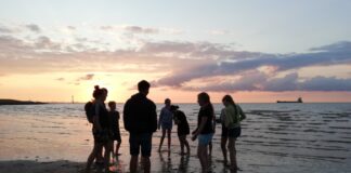Ferienhits 2022 - Jugendgruppe am Strand im Sonnenuntergang