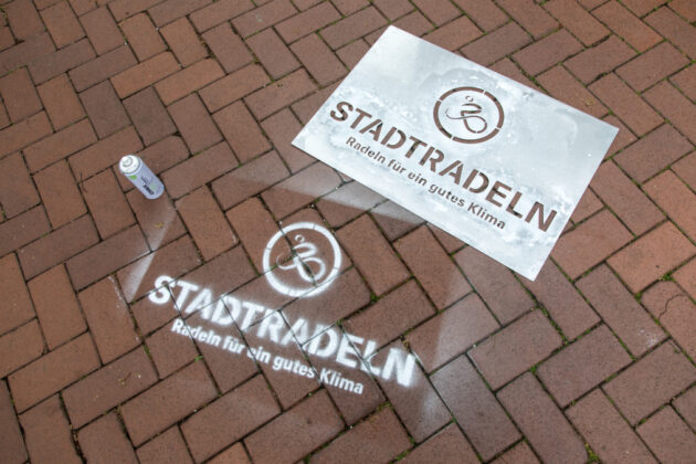 Auch in Langenhagen sollen möglichst viele Logos auf die Radkampagne aufmerksam machen. Bürgermeister Mirko Heuer – unterstützt vom Stadtradeln-Promotion-Team - sprüht mit Kreidespray die Stadtradeln-Logos auf den Boden im Rathaus-Innenhof.