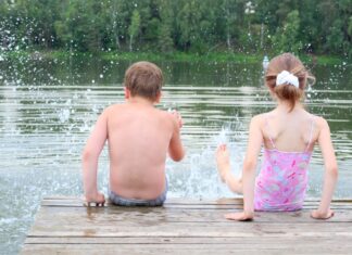 FerienCard-Verkauf startet am 1. Juni Zwei Kinder planschen im Wasser vom Steg aus