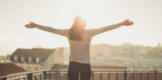 Frau auf Balkon im Sonnenschein/Gegenlicht
