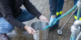 Notversorgung - Trinkwasser wird über Schlauch in Kochtopf gezapft.