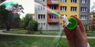 Wohnblock - davor Kinderhand mit Seifenblase