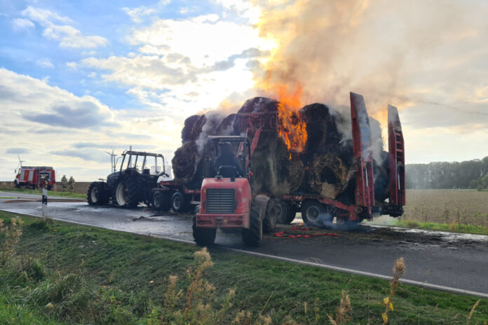 Strohballen brennen auf Traktorgespann.