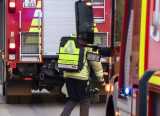 Feuerwehr öffnet Tür gewaltsam Feuerwehrmann mit Rücksack - Türöffnung