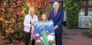 Bea Vogel (mitte) stellt mit ihrer früheren Klassenlehrerin Andrea Breßler und Lions-Präsident Dirk Breuckmann den Adventskalender 2022 vor.