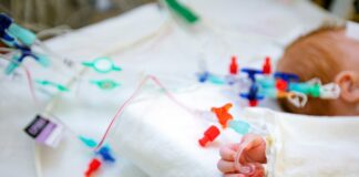 Die Hand eines Säuglings mit einem intravenösen Zugang.