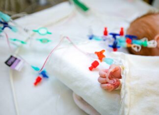 Gute Kooperation der Kinderkliniken auch in Krisenzeiten Die Hand eines Säuglings mit einem intravenösen Zugang.