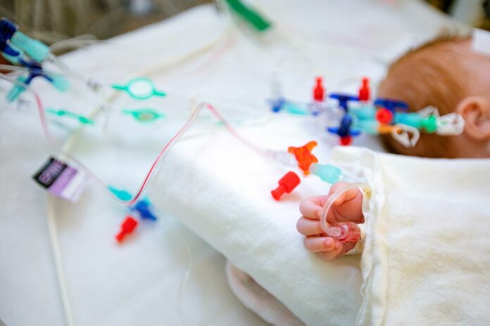 Die Hand eines Säuglings mit einem intravenösen Zugang.