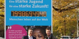 Jan Kreutzberg und Andreas M. Casdorff vor der Weltbevoelkerungsuhr auf dem Zoo-Parkplatz