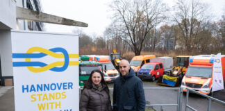 Die Vorsitzende des Ukrainischen Vereins Niedersachsen, Oksana Janzen, und Hannovers Oberbürgermeister Belit Onay stehen vor den Fahrzeugen, die für die ukrainische Stadt Mykolajiw bestimmt sind.