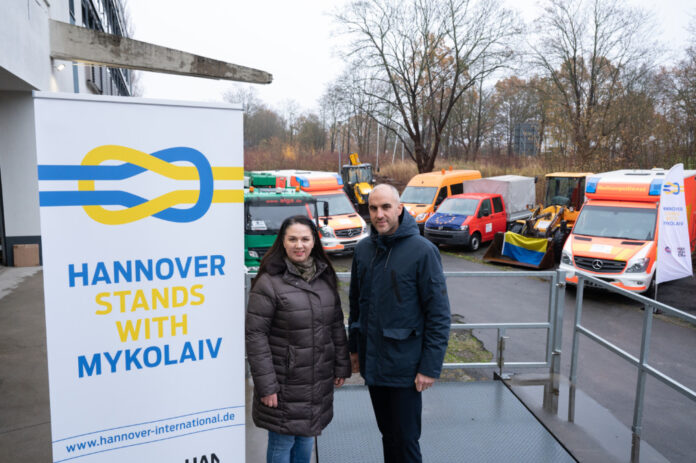 Die Vorsitzende des Ukrainischen Vereins Niedersachsen, Oksana Janzen, und Hannovers Oberbürgermeister Belit Onay stehen vor den Fahrzeugen, die für die ukrainische Stadt Mykolajiw bestimmt sind.