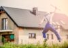 Springender Bauarbeiter vor Haus