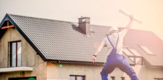 Springender Bauarbeiter vor Haus