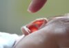 Finger zeigt auf Kinderohr