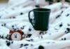 Uhr und Tasse auf Decke