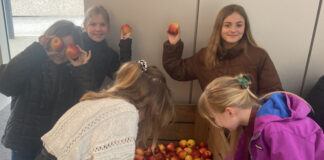 Mia Sophie Heine und Pia Wollenweber von der IGS Langenhagen freuen sich über die gespendeten Äpfel aus dem Alten Land zur fleischlosen Woche.