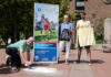 Im Rathaus-Innenhof sprayt Bürgermeister Mirko Heuer (v. li.) im Beisein der Klimaschutzmanagerin Christine Pfülb und Sammy Rehbock von Soulstyle das Stadtradeln-Logo mit Kreide auf das Pflaster