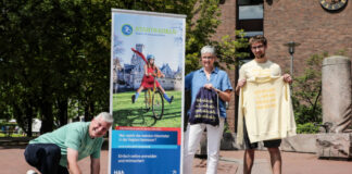 Im Rathaus-Innenhof sprayt Bürgermeister Mirko Heuer (v. li.) im Beisein der Klimaschutzmanagerin Christine Pfülb und Sammy Rehbock von Soulstyle das Stadtradeln-Logo mit Kreide auf das Pflaster
