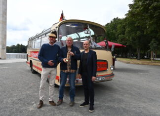 Hannover: Oldtimer-Bus für Stadtrundfahrten ist jetzt elektrisch unterwegs Die BussaNova Classic Tours-Inhaber Thorsten Stahl (v. l.) und Torsten Krüger nehmen von Jens Palandt, Klimadezernent der Region Hannover, den symbolischen Leuchtturm für die Förderung des Bus-Umbaus entgegen.