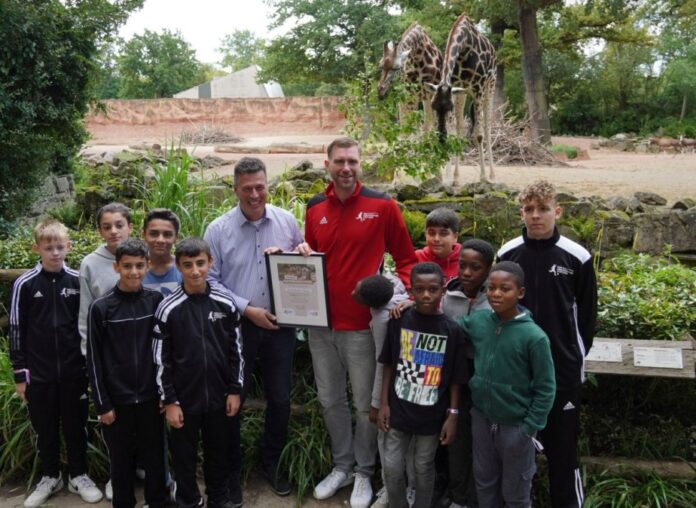 Zoo-Geschäftsführer Andreas M. Casdorff überreicht Per Mertesacker die Urkunde für die Giraffen-Ehrenpatenschaft