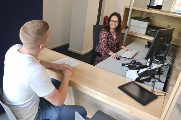 Service Center-Mitarbeiterin Nina Mitschke berät an ihrem neuen Arbeitsplatz einen Kunden.