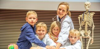 Kinderärztin Professorin Dr. Dr. Christine Happle, wie sie mit Kindern im Hörsaal die Herzdruckmassage übt.
