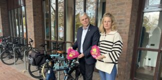 Bürgermeister Mirko Heuer und Gleichstellungsbeauftragte Christiane Hartmann präsentieren die bunten Sattelschoner mit der Telefonnummer des Hilfetelefons.