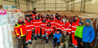 Johanniter-Weihnachtstrucker übergeben Pakete in Rumänien, die dann weiter in die Ukraine transportiert werden.