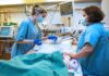 Symbolfoto: Zwei Pflegekräfte auf einer Intensivstation am Bett eines Patienten.