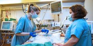 Symbolfoto: Zwei Pflegekräfte auf einer Intensivstation am Bett eines Patienten.