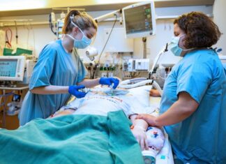 Die MHH zählt zu den besten Kliniken der Welt Symbolfoto: Zwei Pflegekräfte auf einer Intensivstation am Bett eines Patienten.