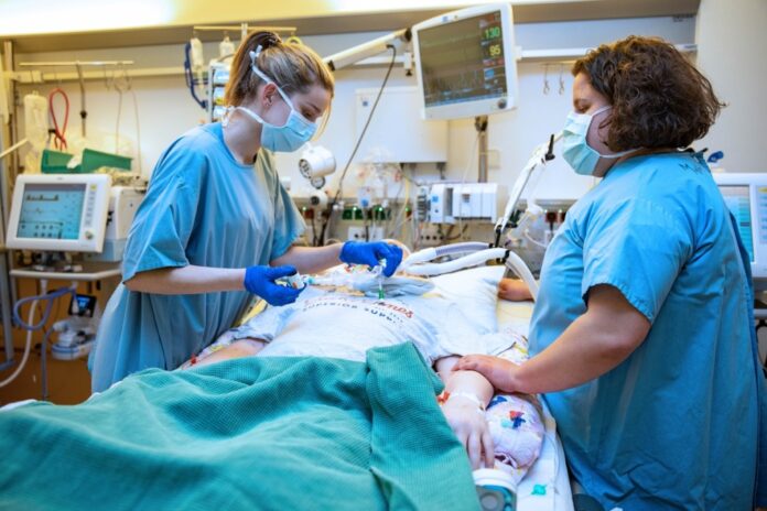 Symbolfoto: Zwei Pflegekräfte auf einer Intensivstation am Bett eines Patienten.