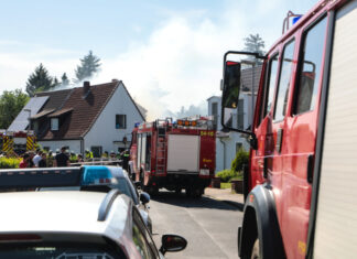 Anbau gerät in Brand und droht Wohnhaus zu zerstören a fire truck on the road