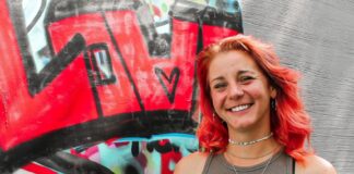Rosalie Borchert steht vor den Graffiti-Arbeiten der Jugendlichen im Jugendzentrum.