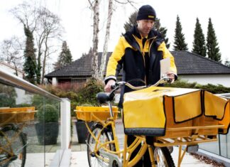 Deutsche Post kündigt höhere Brief- und Paketpreise ab 2025 an Symbolbild: DHL Group Zusteller