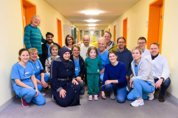 Das Foto zeigt das interdisziplinäre und interprofessionelle Team aus Ärztinnen, Ärzten und Pflegekräften der pädiatrischen Pneumologie, Kinderintensivmedizin sowie HTTG-Chirurgie, Physiotherapeutinnen, Ernährungsberaterinnen und einer Transplantationskoordinatorin. Sie alle – und viele weitere – haben dazu beigetragen, dass es der fünfjährigen Rukeia nach ihrer Lungentransplantation im Herbst 2024 deutlich besser geht.