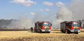 Ballenpresse und Stoppelfeld stehen in Flammen