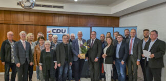 Mirko Heuer (Mitte) bekommt im Kreise der Mitglieder vom CDU-Stadtverbandsvorsitzenden Sebastian Kurbach (rechts davon) Blumen und ein Präsent zur Nominierung überreicht