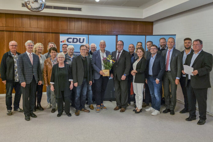 Mirko Heuer (Mitte) bekommt im Kreise der Mitglieder vom CDU-Stadtverbandsvorsitzenden Sebastian Kurbach (rechts davon) Blumen und ein Präsent zur Nominierung überreicht