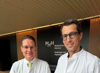 Weltpremiere an der MHH: Herzdaten fließen erstmals in Echtzeit in die elektronische Patientenakte Klinikdirektor Professor Dr. Johann Bauersachs (links) und Professor Dr. David Duncker zeigen, wie einfach es geht: Finger aufs Gerät legen und schon werden die EKG-Daten erfasst.