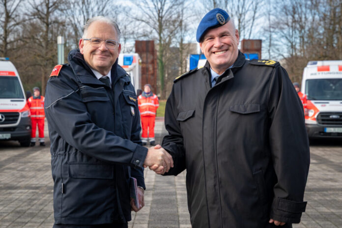 Oliver Meermann, Mitglied des Bundesvorstandes der Johanniter-Unfall-Hilfe und Generaloberstabsarzt Dr. Ralf Hoffmann, Befehlshaber des Zentralen Sanitätsdienstes der Bundeswehr (v.l.n.r.) stellen gemeinsam die Verwundeten-Transportkomponente 100 der Johanniter vor.